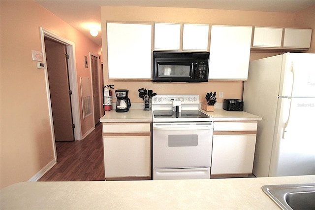 kitchen with white appliances, white cabinetry, and dark hardwood / wood-style flooring