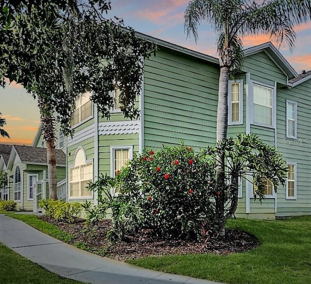 property exterior at dusk with a lawn