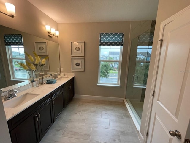 bathroom with tile patterned floors, a shower with door, a textured ceiling, and vanity