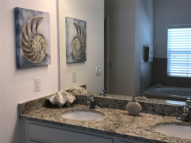 bathroom with vanity and a washtub