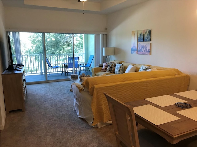 carpeted living room featuring a wealth of natural light, a high ceiling, and ceiling fan