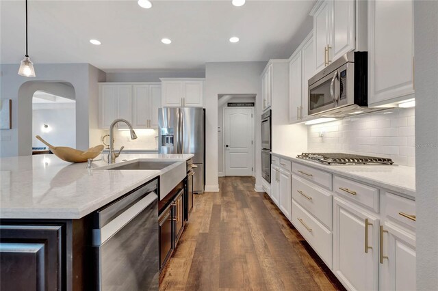 kitchen featuring stainless steel appliances, dark hardwood / wood-style floors, decorative backsplash, and white cabinets