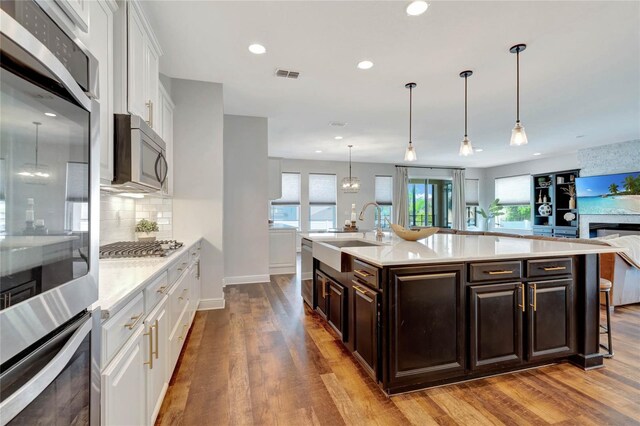 kitchen featuring light wood-type flooring, white cabinets, stainless steel appliances, and sink