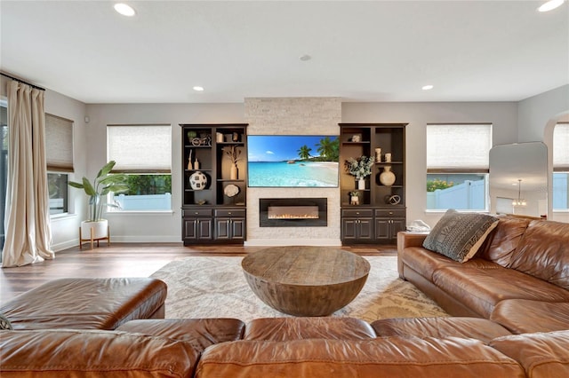 living area with baseboards, a fireplace, wood finished floors, and recessed lighting