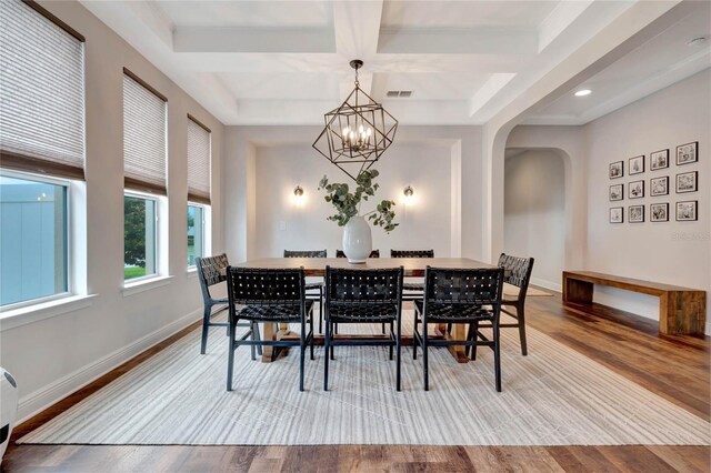 dining room featuring coffered ceiling, light hardwood / wood-style flooring, a chandelier, and beam ceiling