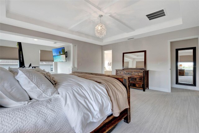 bedroom with decorative columns, a chandelier, a raised ceiling, and carpet floors