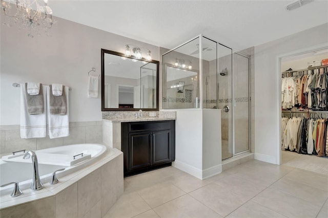 bathroom featuring a garden tub, tile patterned flooring, vanity, a spacious closet, and a shower stall