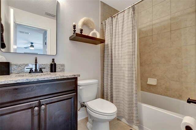 full bathroom featuring tile patterned flooring, toilet, ceiling fan, shower / bath combo with shower curtain, and vanity