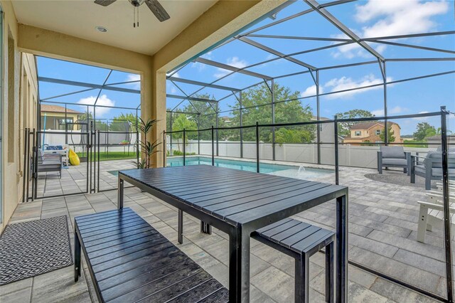 view of patio featuring a lanai, ceiling fan, and a fenced in pool