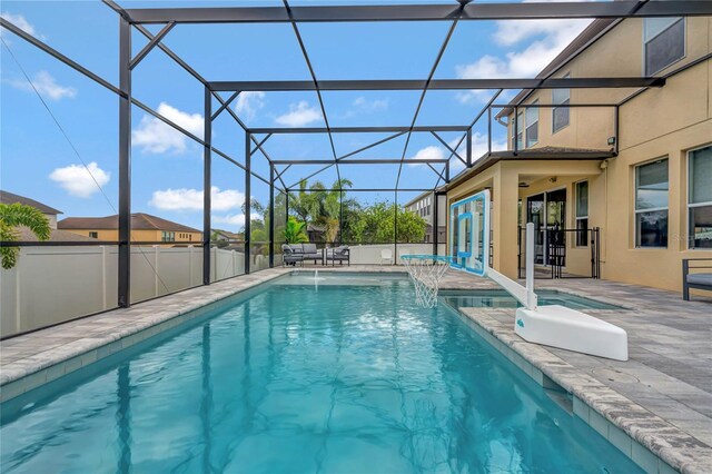 view of swimming pool featuring pool water feature, a lanai, and a patio