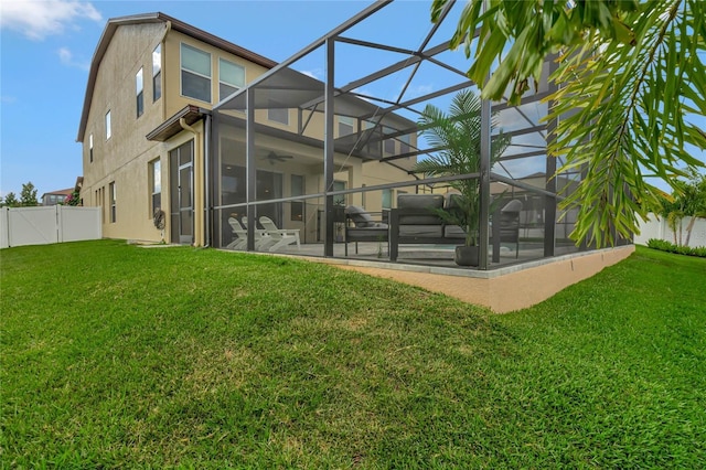 back of property featuring a yard, a patio, stucco siding, ceiling fan, and a fenced backyard