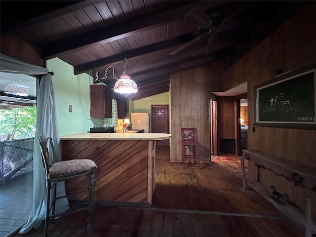 kitchen featuring wood walls, wood ceiling, white fridge, lofted ceiling with beams, and kitchen peninsula