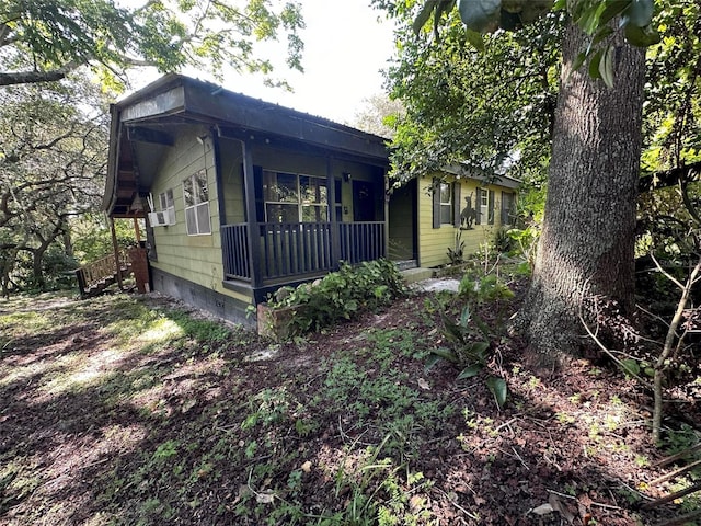 view of side of property with covered porch and cooling unit