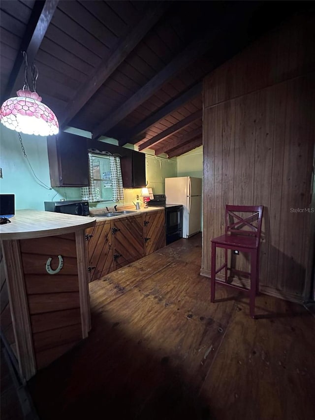 kitchen with beamed ceiling, black appliances, dark hardwood / wood-style floors, and pendant lighting