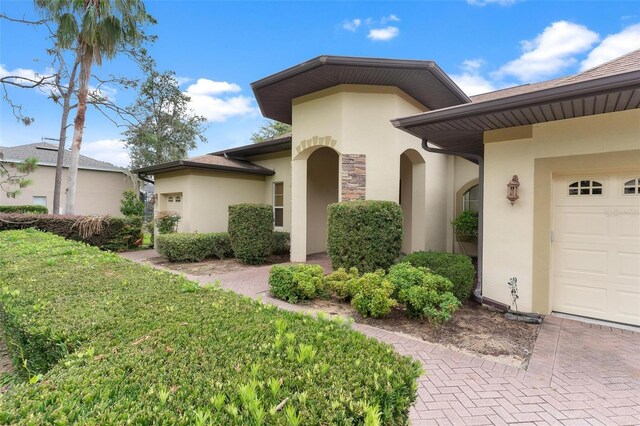 entrance to property with a garage and a lawn