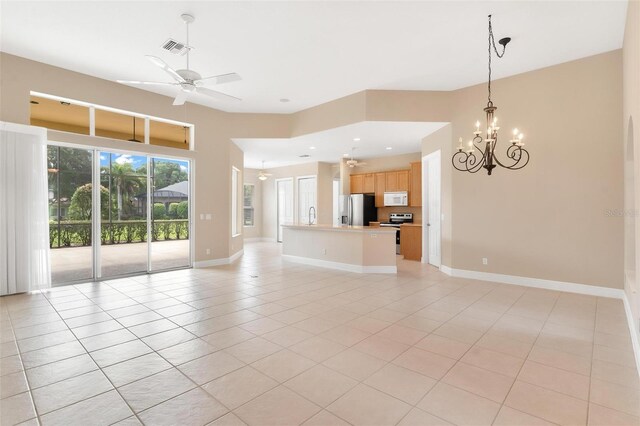 unfurnished living room featuring sink, ceiling fan with notable chandelier, and light tile patterned floors