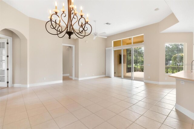 unfurnished room featuring light tile patterned floors and ceiling fan with notable chandelier