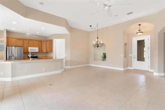 kitchen featuring appliances with stainless steel finishes, decorative light fixtures, and ceiling fan with notable chandelier