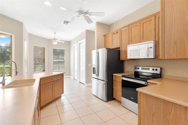 kitchen with ceiling fan, appliances with stainless steel finishes, sink, and light tile patterned floors