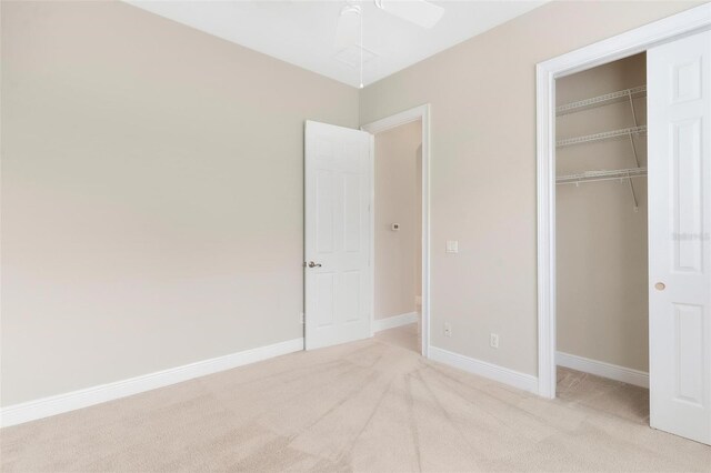 unfurnished bedroom featuring a closet, ceiling fan, and light carpet