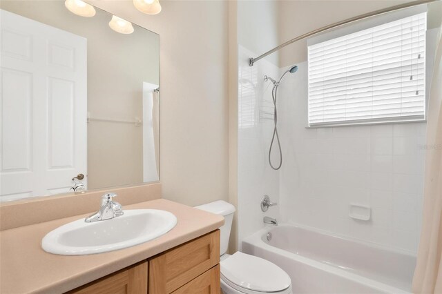 full bathroom with vanity, tiled shower / bath combo, and toilet