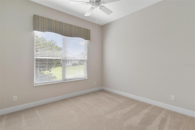 spare room with ceiling fan and light carpet