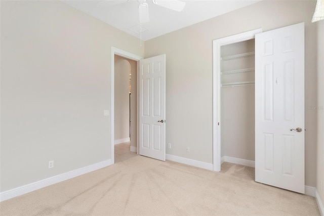 unfurnished bedroom featuring a closet, ceiling fan, and light colored carpet