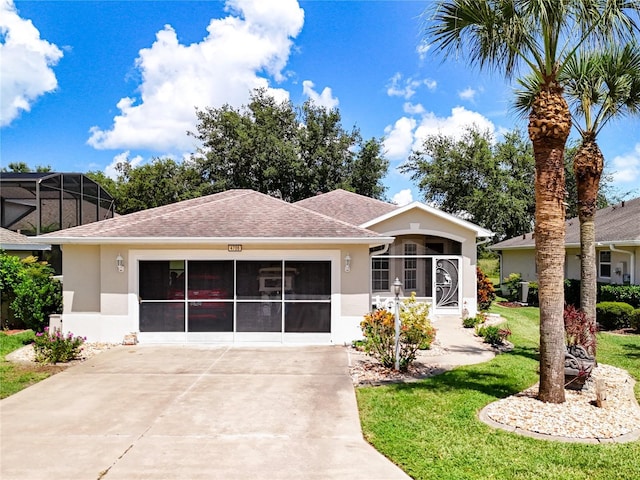 view of front of home featuring stucco siding, a shingled roof, a front yard, a garage, and driveway