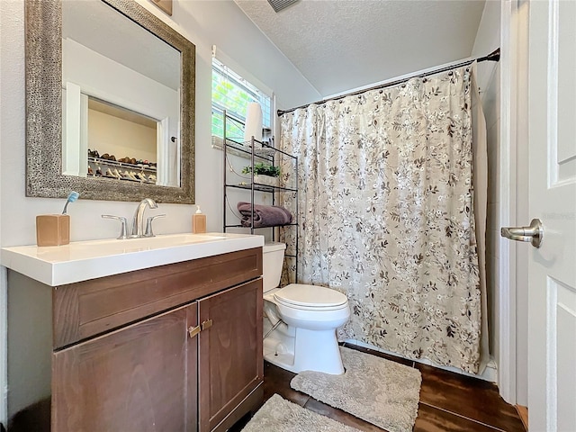 bathroom with hardwood / wood-style floors, a textured ceiling, toilet, vanity, and curtained shower