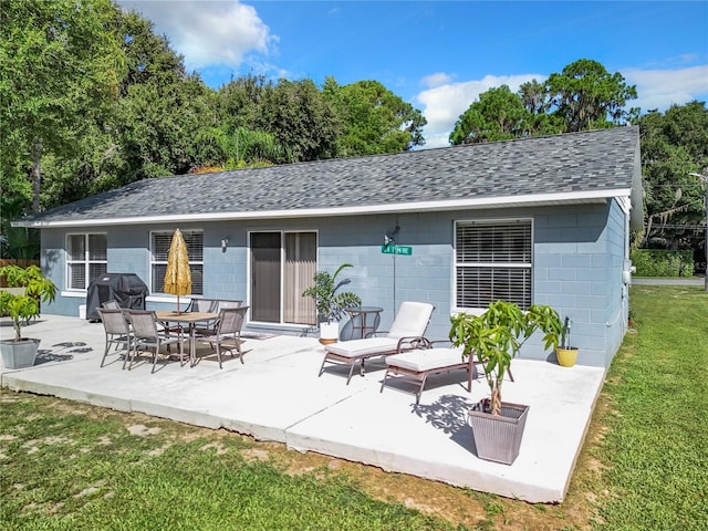 rear view of house featuring a patio and a lawn