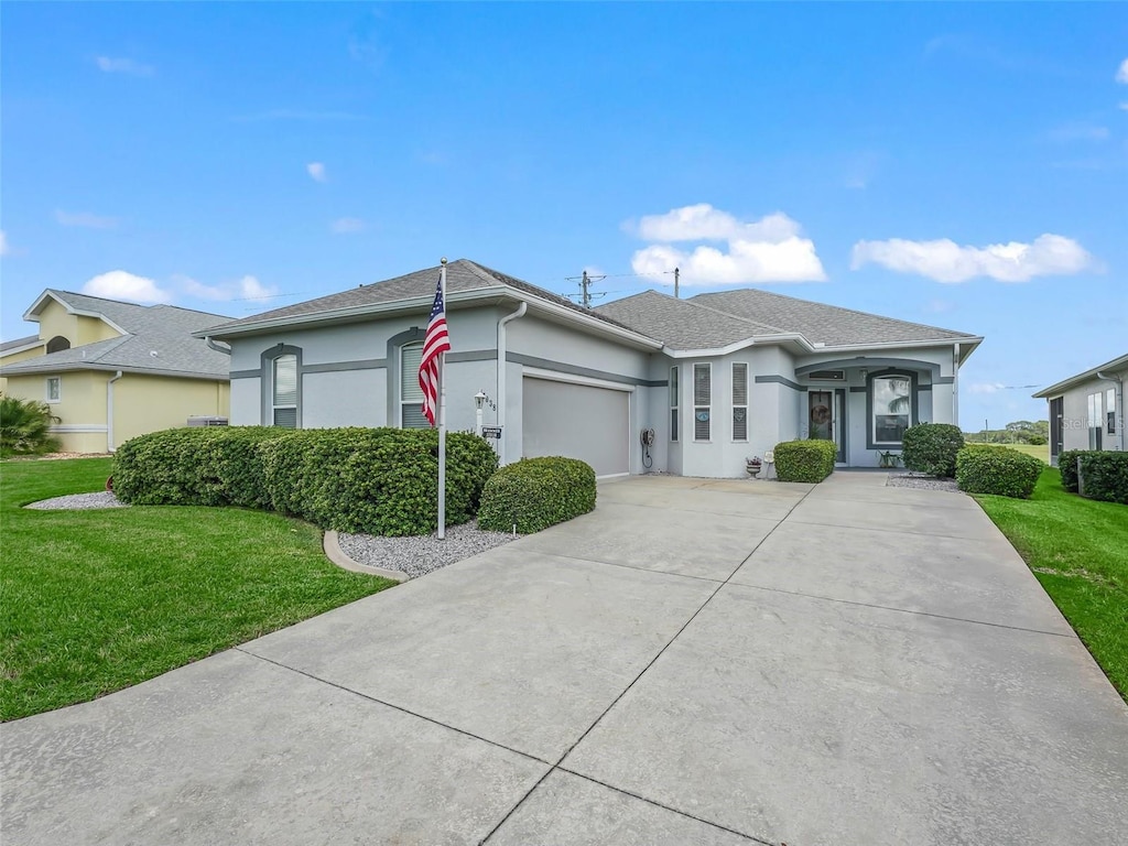 single story home featuring a garage and a front lawn