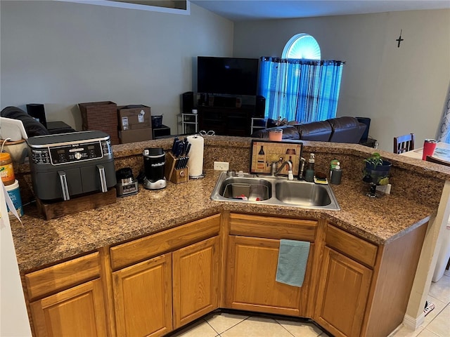 kitchen featuring stone counters, sink, and light tile patterned flooring