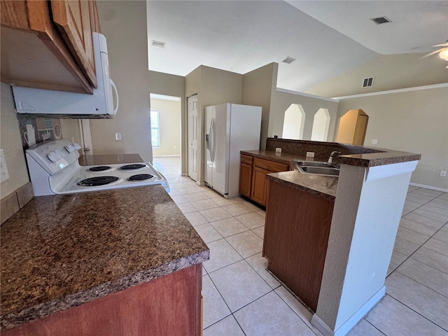 kitchen with sink, kitchen peninsula, vaulted ceiling, white appliances, and light tile patterned floors