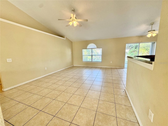 spare room with ceiling fan, light tile patterned floors, a healthy amount of sunlight, and lofted ceiling