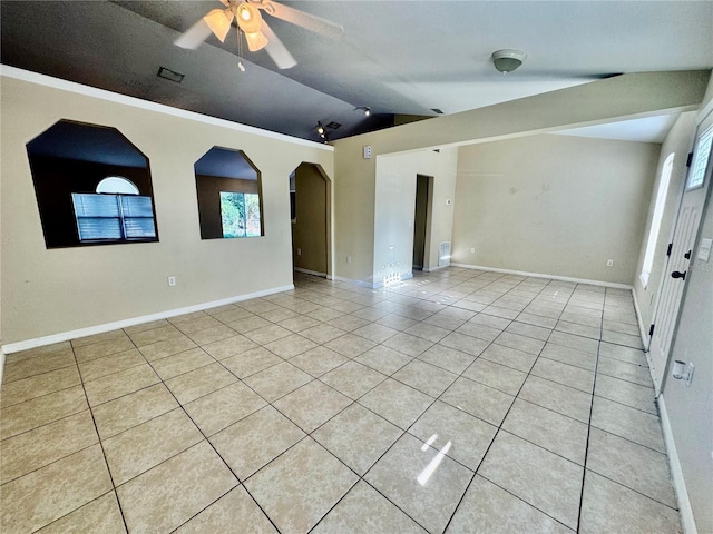 empty room with light tile patterned flooring, plenty of natural light, lofted ceiling, and ceiling fan