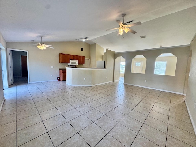 unfurnished living room with ceiling fan, light tile patterned flooring, and lofted ceiling