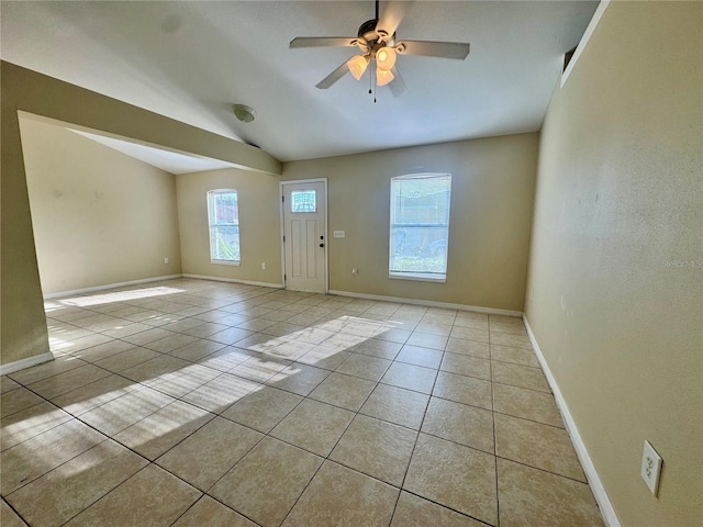 foyer entrance with ceiling fan, lofted ceiling, and light tile patterned floors