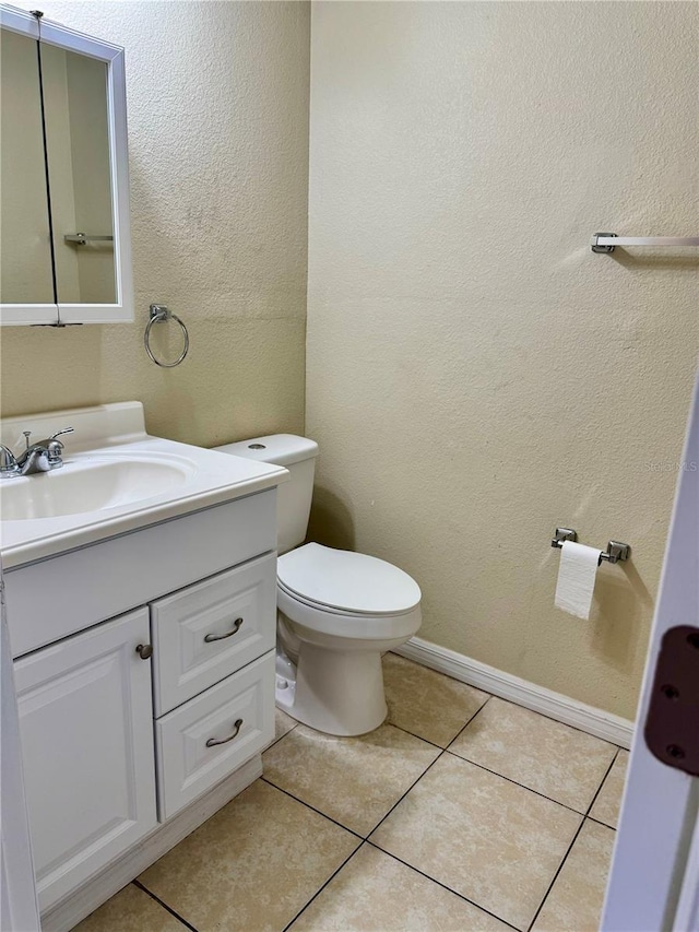 bathroom featuring tile patterned floors, vanity, and toilet