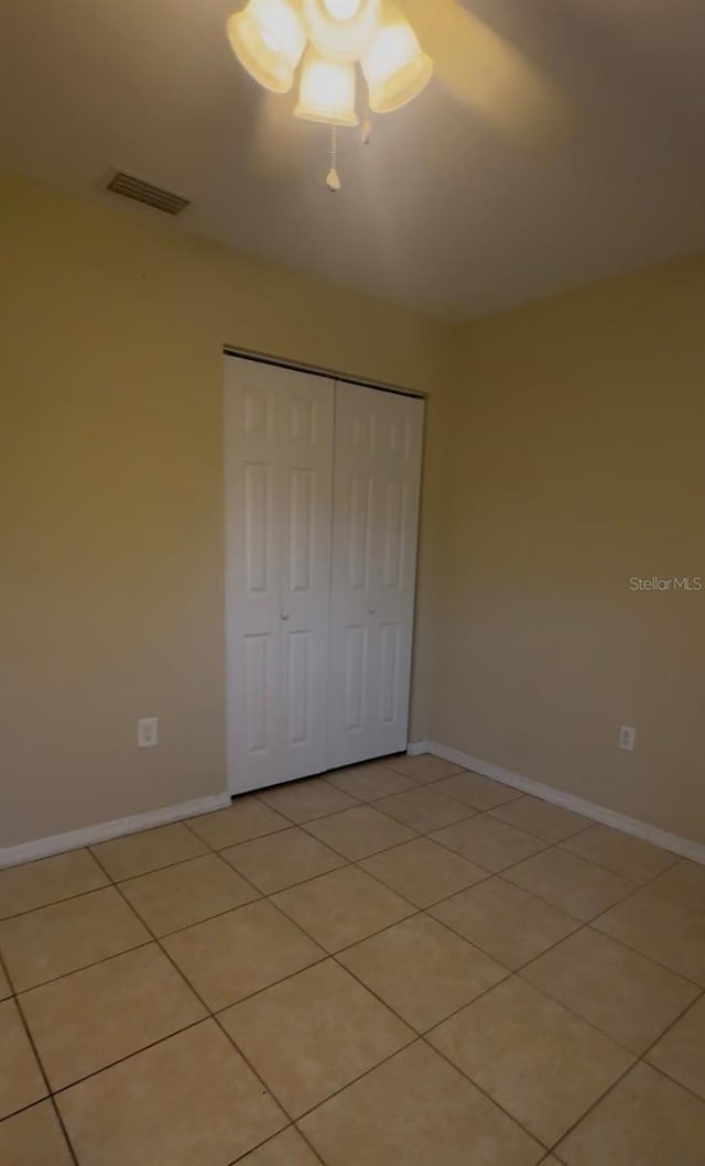 unfurnished bedroom with light tile patterned floors and a closet