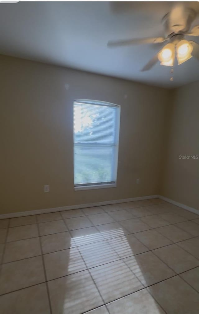 tiled empty room with ceiling fan