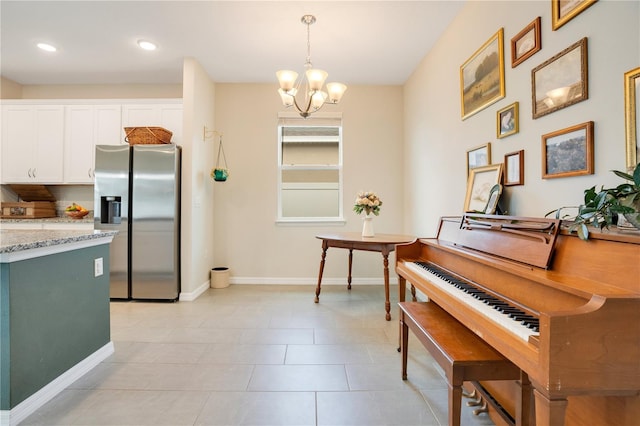 miscellaneous room with light tile patterned floors and an inviting chandelier