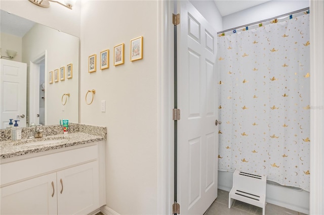 bathroom with tile patterned flooring, vanity, and walk in shower