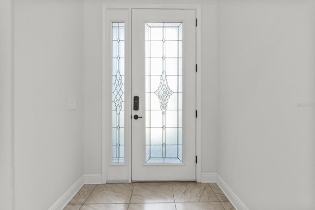 doorway to outside with light tile patterned floors