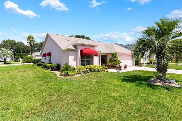 view of front of home featuring a garage, a front yard, driveway, and stucco siding