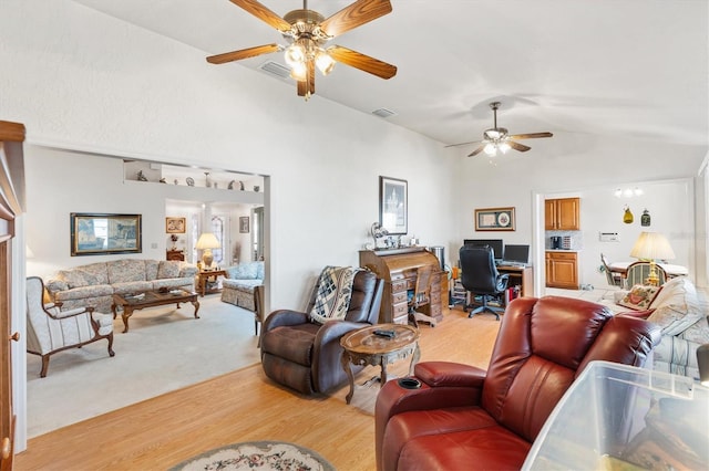 living room with lofted ceiling, ceiling fan, and light carpet