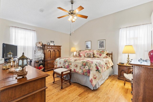 bedroom featuring ceiling fan, vaulted ceiling, and light hardwood / wood-style flooring