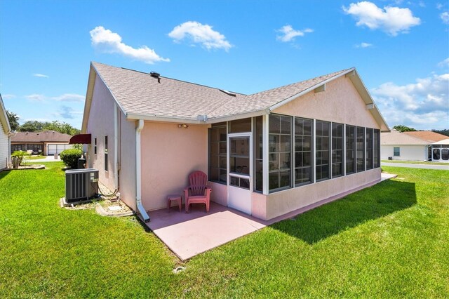 back of house featuring a sunroom, stucco siding, a yard, and central air condition unit