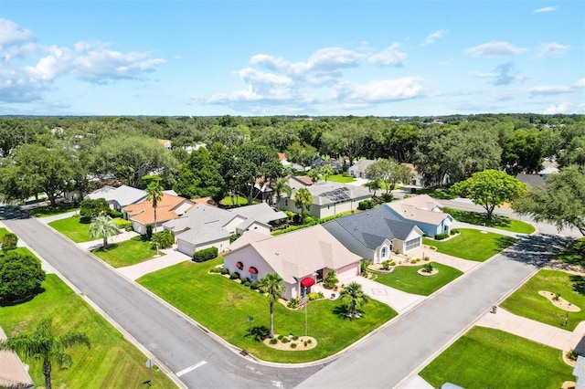 drone / aerial view with a wooded view and a residential view