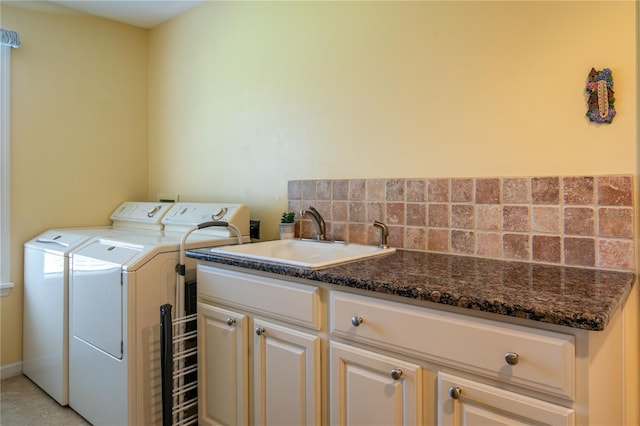 washroom featuring washing machine and clothes dryer, sink, and cabinets