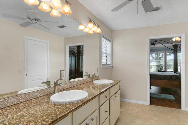 bathroom featuring vanity, a textured ceiling, a wealth of natural light, and tile patterned flooring